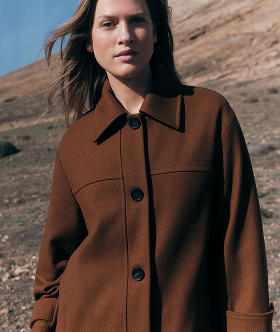 Weibliches Model trägt faire braune Jacke von Lanius in der Wüste